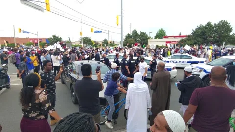 Scary time for too few cops surrounded by angry crowd in rally at street corner Stock Footage 133975320