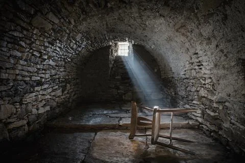 Scary underground, old dark cellar with an old abandoned chair Stockfoto's
