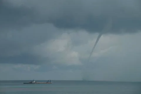 Scary waterspout or tornado forms in the Atlantic near beach  Stock Photos