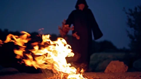 Scary witch conjures around the fire. A terrible ritual. Halloween. Horror. Video stock 114688101