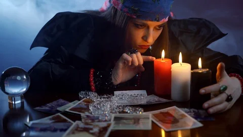 Scary witch with devil eyes starring on candles and performing magic ritual in Stock Footage 127870035
