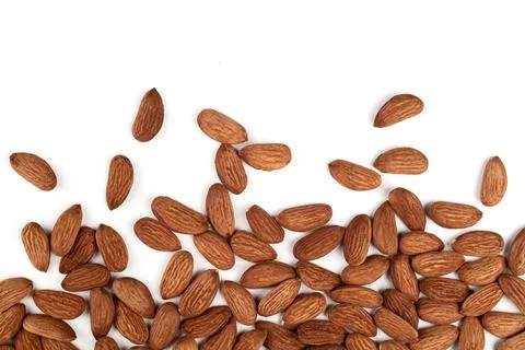 Scattered almonds on a white background. Stock Photos