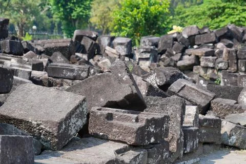 Scattered ancient stone blocks and ruins at an archaeological temple site. Stock Photos