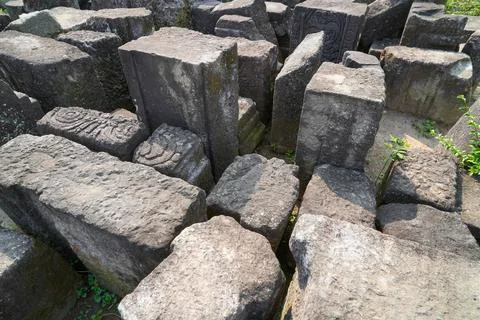 Scattered ancient stone blocks and ruins at an archaeological temple site. 스톡 사진