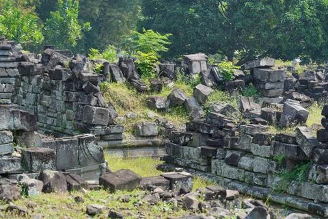Scattered ancient stone blocks and ruins at an archaeological temple site. 스톡 사진