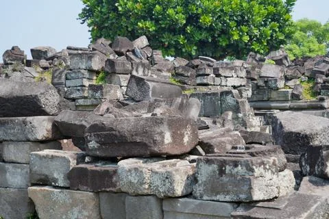 Scattered ancient stone blocks and ruins at an archaeological temple site. Stock Photos