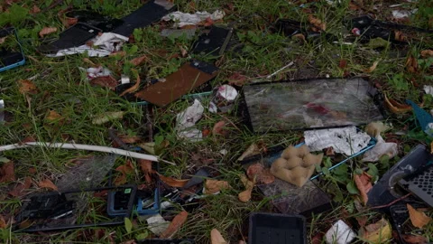 Scattered broken electronic devices and glass on grassy ground with fallen Stock Footage 344969127
