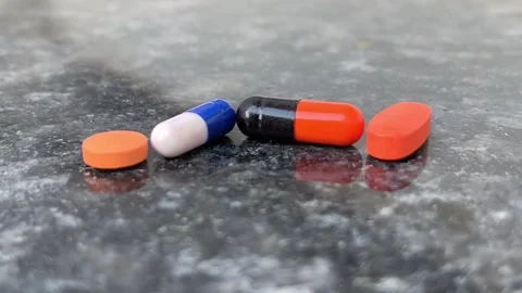 Scattered Capsules and Tablets on Ground Close-Up | Medicine Spill Scene Видео 321629817