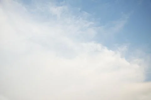 Scattered cloud clusters in a blue sky, blue sky background with white clouds 库存照片