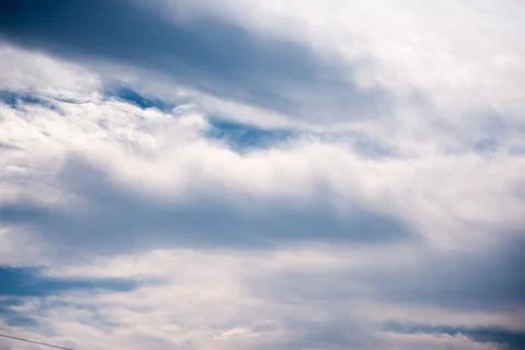 Scattered cloud clusters in a blue sky, blue sky background with white clouds 库存照片