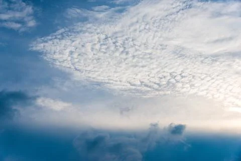 Scattered cloud clusters in a blue sky, blue sky background with white clouds 库存照片