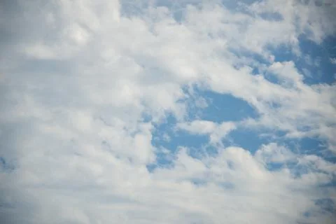 Scattered cloud clusters in a blue sky, blue sky background with white clouds Stock Photos