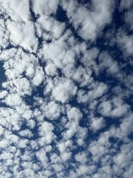 Scattered clouds in blue sky forming abstract pattern suitable for use as a.. 写真素材