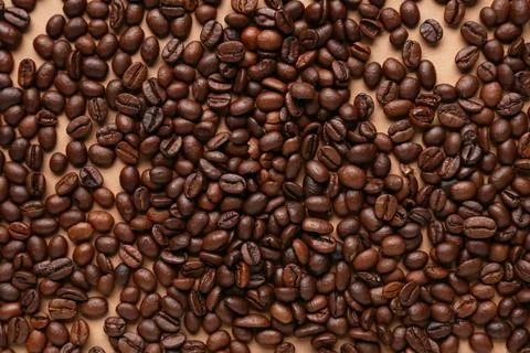 Scattered coffee beans on beige background Stock Photos