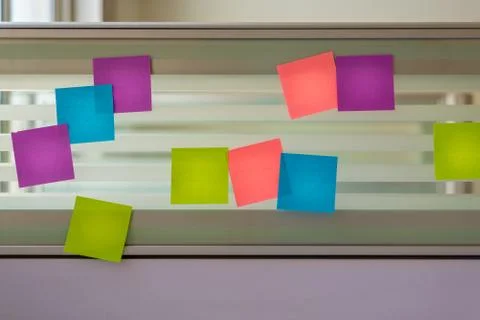 Scattered colored sticky notes over glass screen of a bench desk Stock Photos