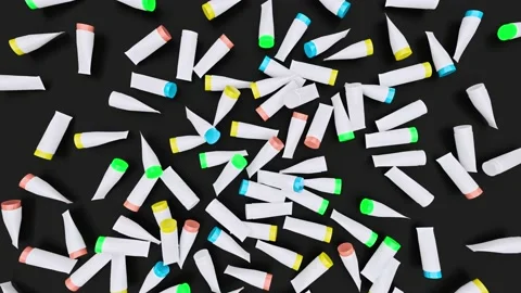 Scattered Colorful Plastic Tubes on Black surface wiped to create space for text Stock Footage 201105846
