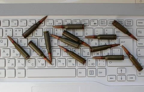 Scattered Combat Bullets on a White Bilingual Keyboard 스톡 사진