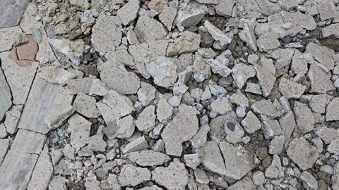Scattered concrete debris on cracked ground surface top view of a destroyed Vídeo Stock 342586583