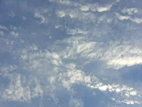Scattered cumulus clouds floating in a vibrant blue sky provide a sense of op Photos