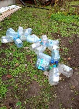 Scattered empty plastic five-liter bottles with caps from under water on th.. Stock Photos