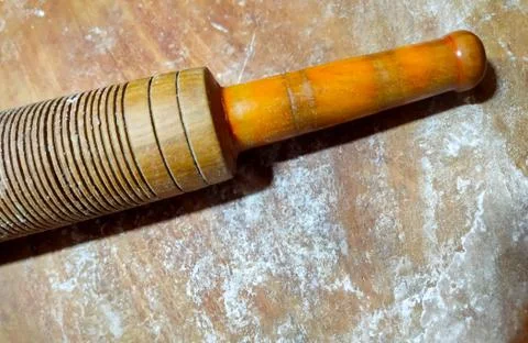 Scattered flour and part of a rolling pin on wooden board. Stock Photos