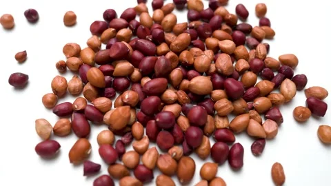 Scattered fresh peanuts rotating view on white table background Stock Footage 282849130