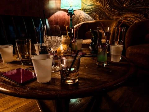 Scattered glasses and empty drinks on a bar table after a party Stock Photos