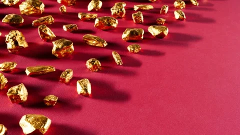 Scattered Gold Nuggets on Red Background Stock Footage 288976189