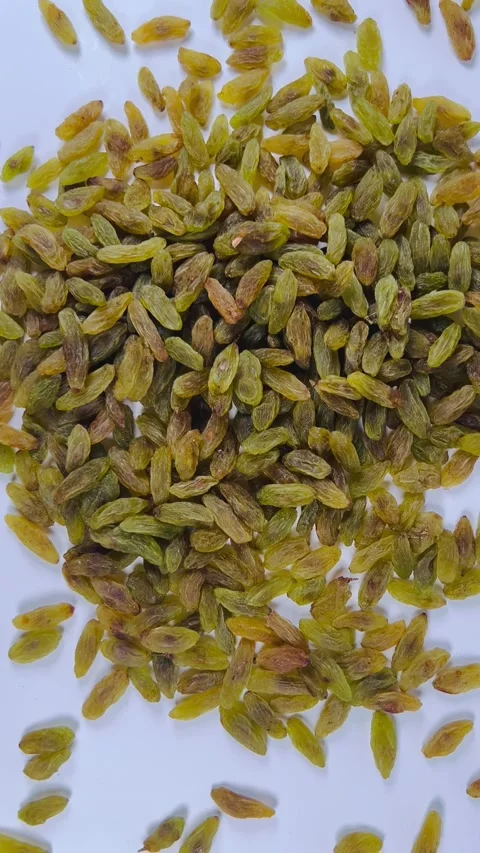 Scattered green raisins, white background, vertical, top view Stock Footage 336848088