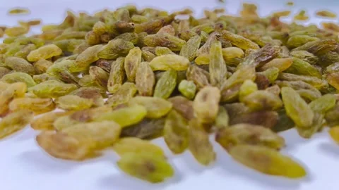 Scattered green raisins, white background, horizontal, low angle Stock Footage 336848089