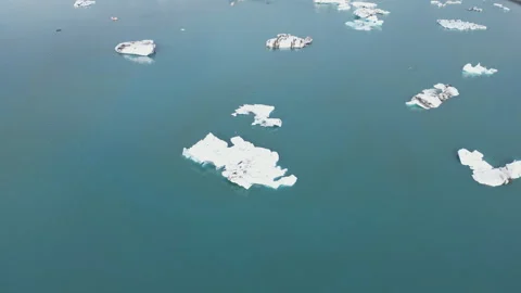 Scattered icebergs floating in deep, dark blue glacial water. Stock Footage 332573729
