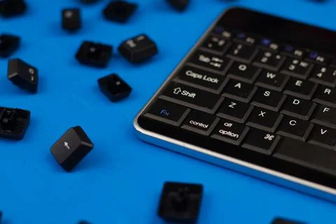 Scattered keys from the computer around the keyboard on an isolated blue Stock Photos