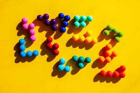 Scattered multicolored puzzle elements on yellow background Stock Photos