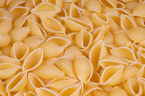 Scattered pasta shells ready recipe prep, tactile semolina dust, rustic cooking Stock Photos