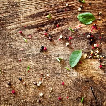 Scattered peppercorns and basil Stock Photos