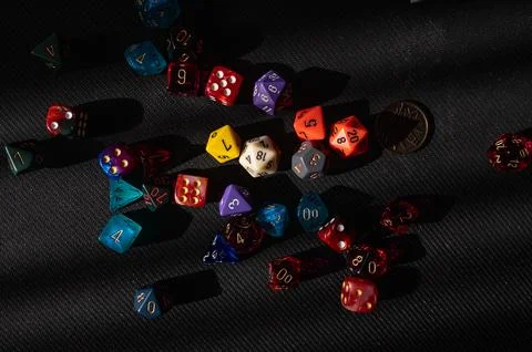 Scattered Polyhedral Dice on Black Background Stock Photos