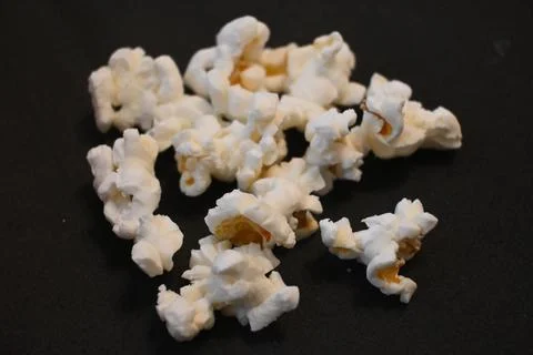 Scattered popcorn on a black background Stock Photos