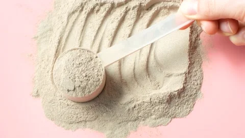 Scattered protein and measuring spoon on pink background top view, concert of Stock Footage 236449145