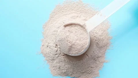 Scattered protein and measuring spoon on blue background, concept of sports Stock Footage 238056352