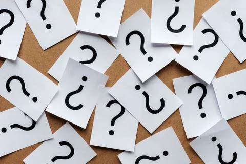 Scattered question marks printed on white paper Stock Photos