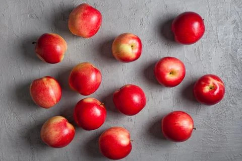 Scattered Red Apples on Light Gray Concrete Background Stock Photos