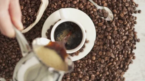 Scattered roasted arabica coffee beans in craft bag and around. Brown paper Stock Footage 156238458
