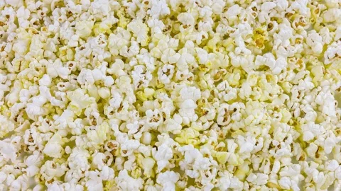 Scattered salted popcorn, texture background. Popcorn rotates. Видео 76269981