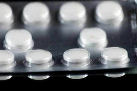 Scattered tablets on a black background, pills reflected in the mirror Stock Photos