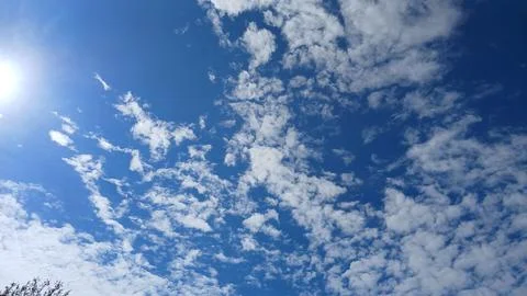 Scattered White Clouds Across a Bright Blue Sky 스톡 사진