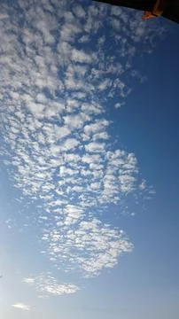 Scattered White Clouds Against a Bright Blue Sky 스톡 사진