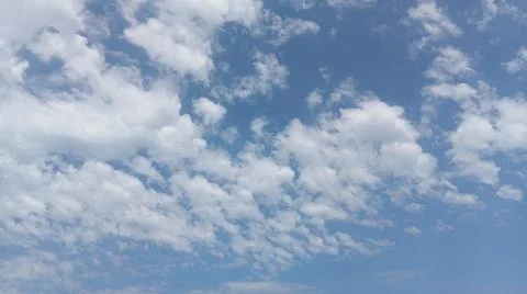 Scattered white clouds against a bright blue sky Stock Photos