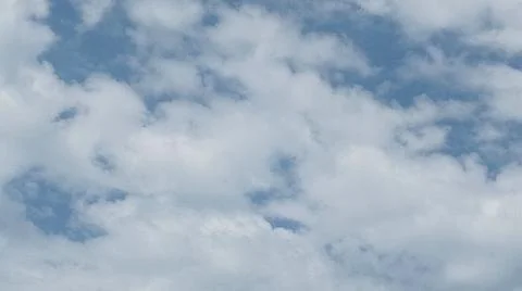 Scattered white clouds against a bright blue sky Stock Photos