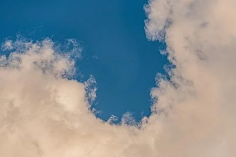 Scattered white clouds on a bright, clear blue sky Soft lighting suggests ear Stockfoto's