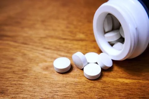 Scattered white pills on the table Stock Photos